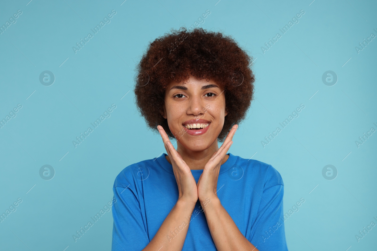 Photo of Portrait of happy young woman on light blue background