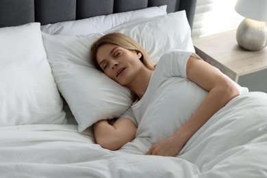 Photo of Woman snoring while sleeping in bed at home