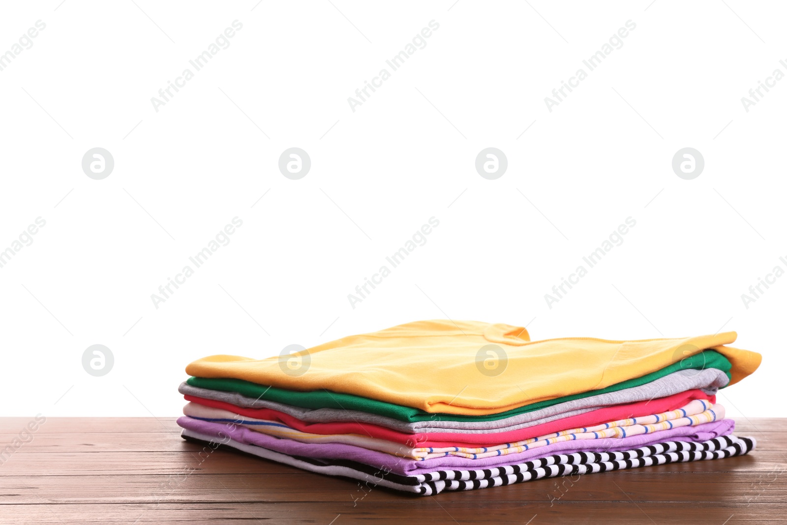 Photo of Pile of ironed clothes on table against white background