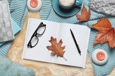 Photo of Flat lay composition with book, cup of coffee and warm blanket on fuzzy rug