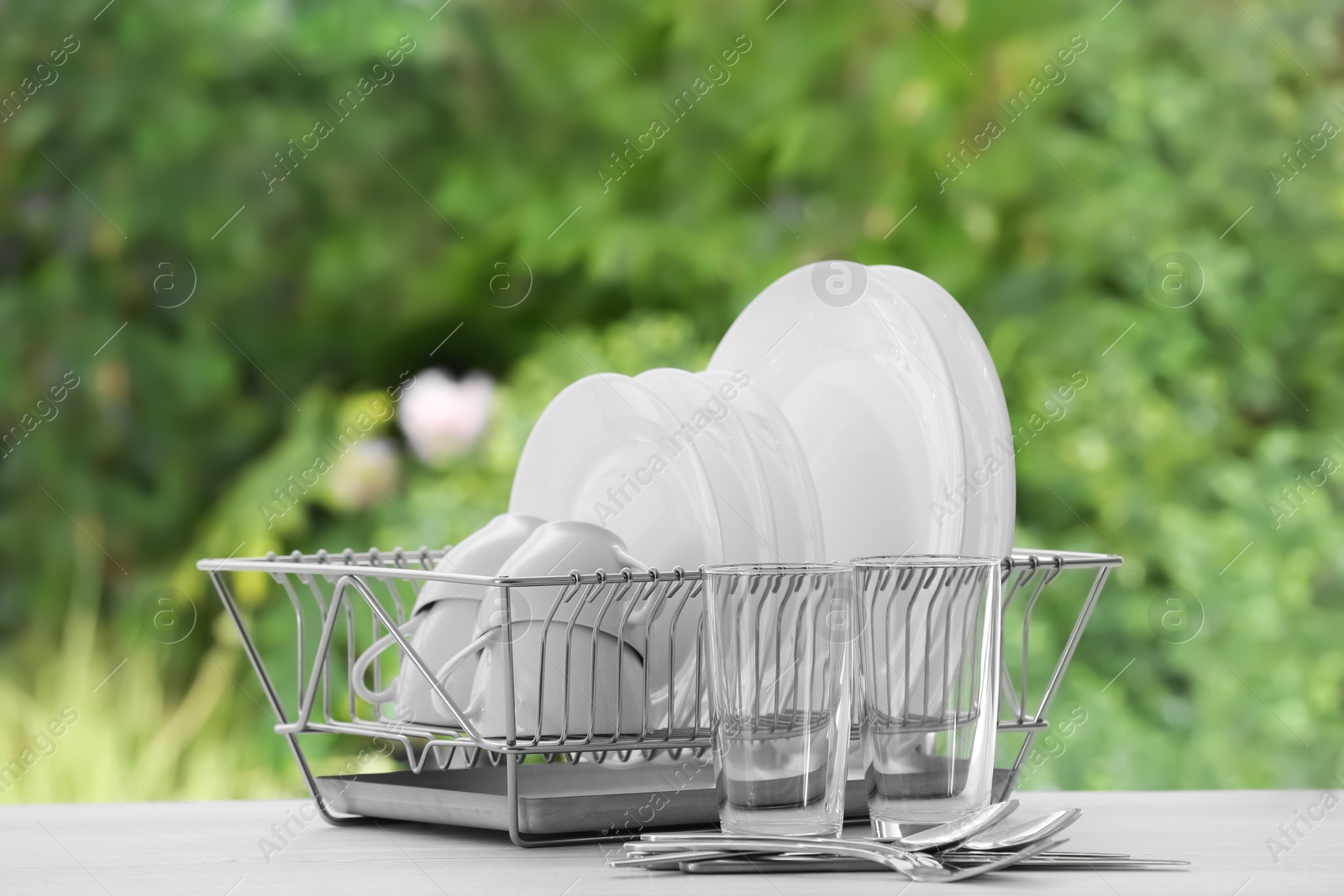 Photo of Set of clean dishware on table against blurred background