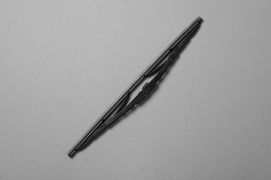 Car windshield wiper on grey background, top view