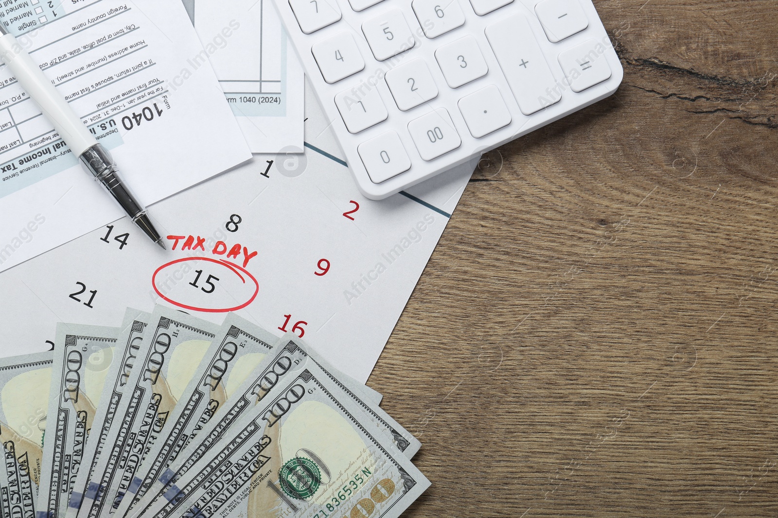 Photo of Calendar with date reminder about tax day, documents, pen, money and calculator on wooden table, flat lay. Space for text