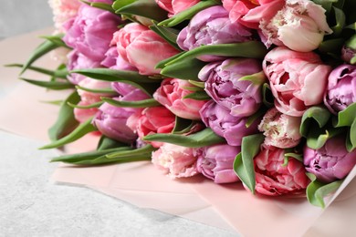 Bouquet of beautiful tulips on white table, closeup