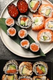 Delicious sushi rolls on grey table, flat lay