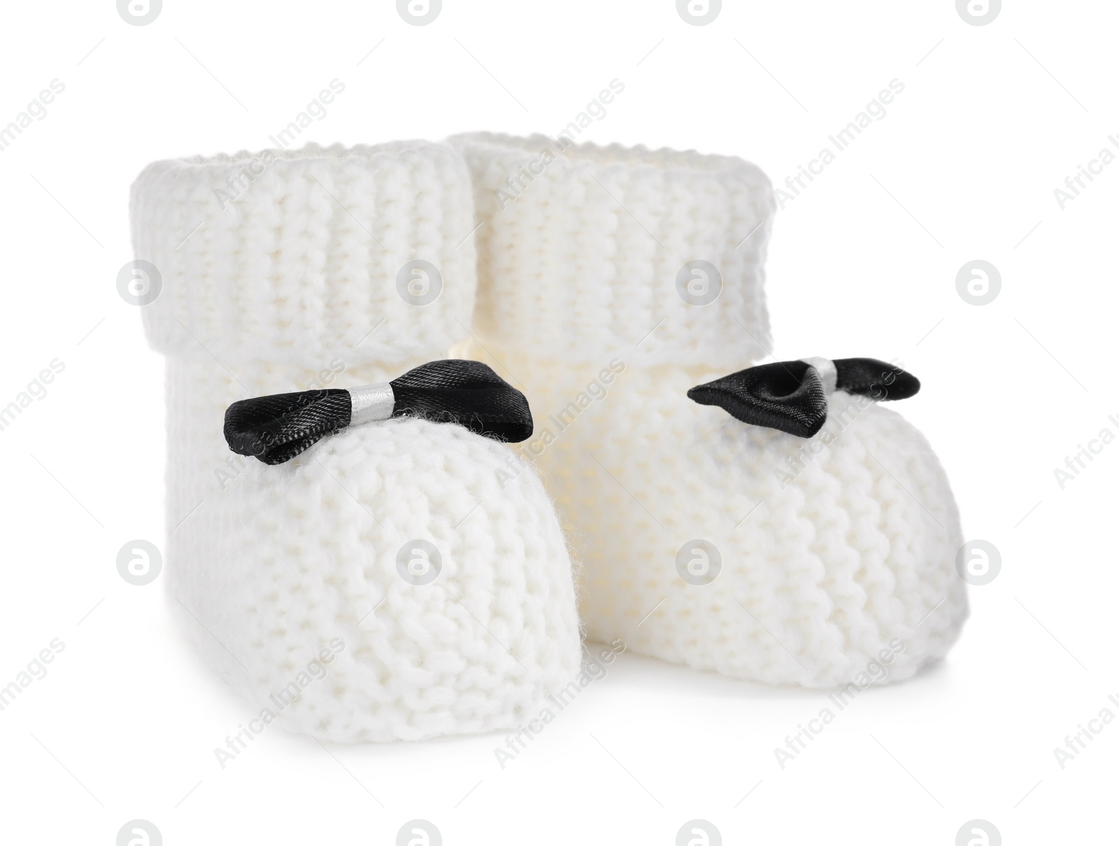 Photo of Handmade baby booties with bows isolated on white