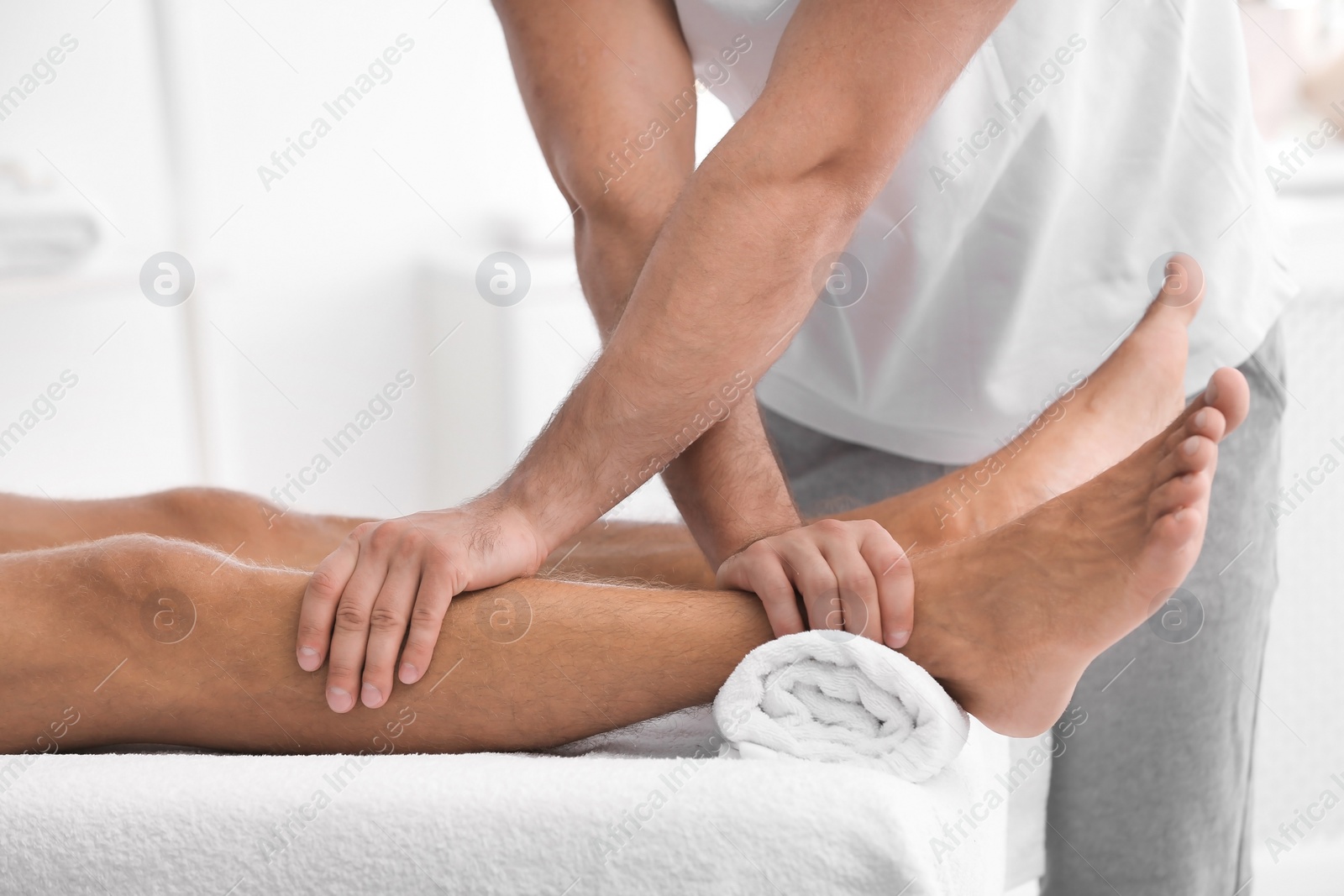 Photo of Young man receiving massage in salon, closeup