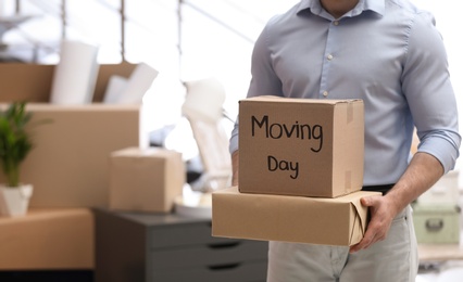 Man holding moving boxes in new office, closeup. Space for text