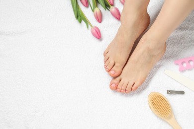 Photo of Woman with neat toenails after pedicure procedure on white terry towel, closeup. Space for text