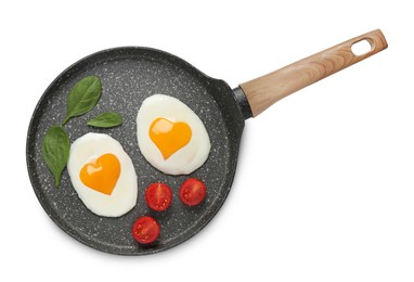 Image of Frying pan with tasty fried eggs with yolks in shape of heart and tomato on white background, top view