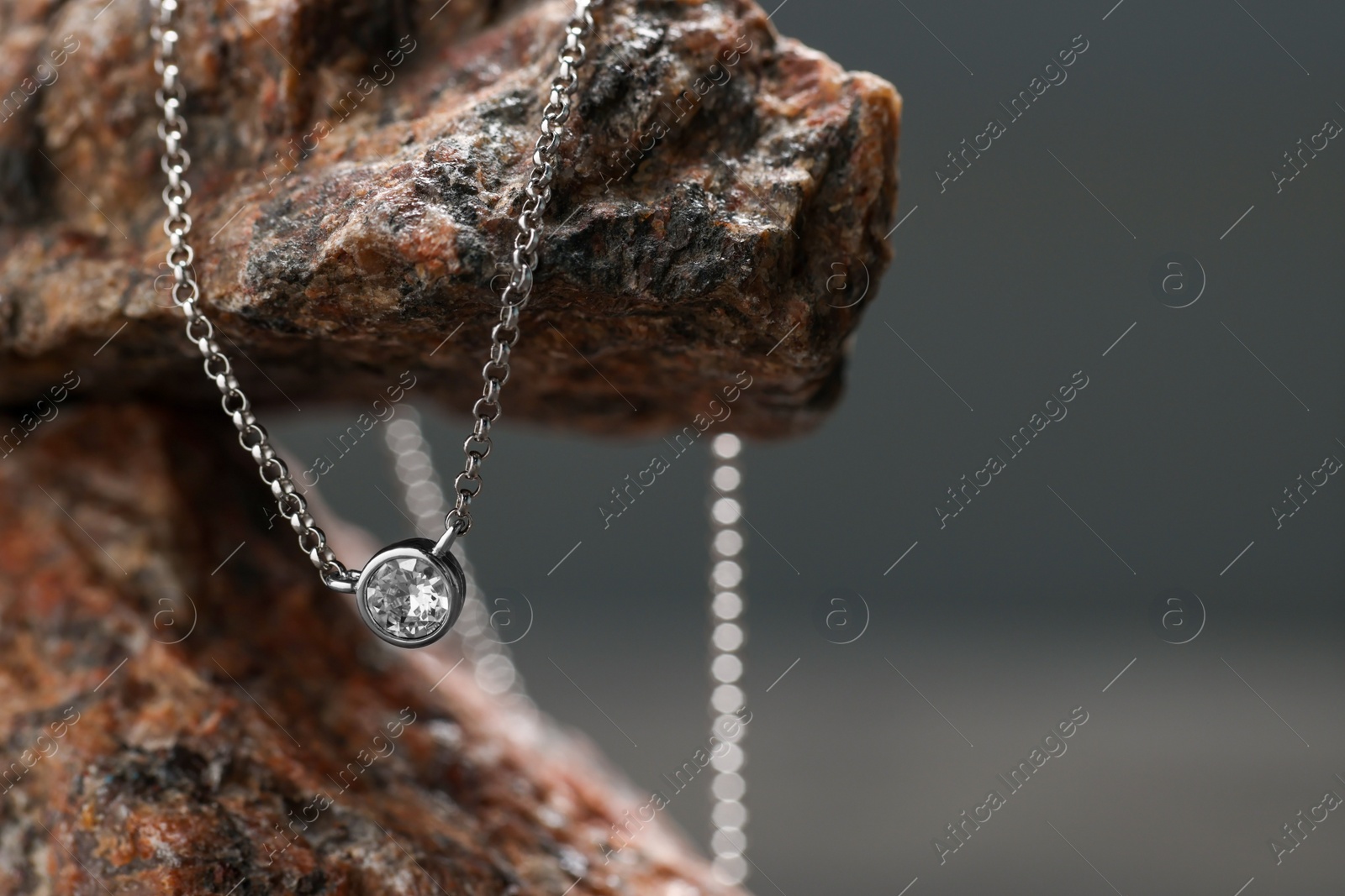 Photo of Beautiful necklace on stone stand, space for text. Luxury jewelry