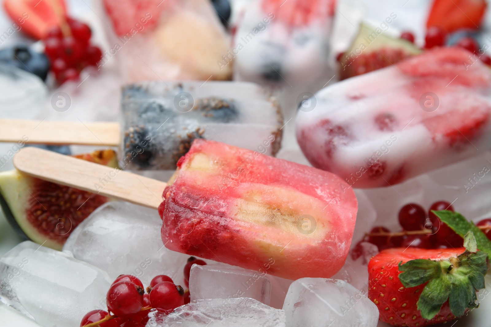 Photo of Tasty refreshing fruit and berry ice pops on table, closeup