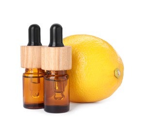 Photo of Bottles of citrus essential oil and fresh lemon isolated on white