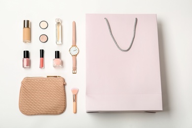 Photo of Flat lay composition with shopping bag and cosmetics on white background