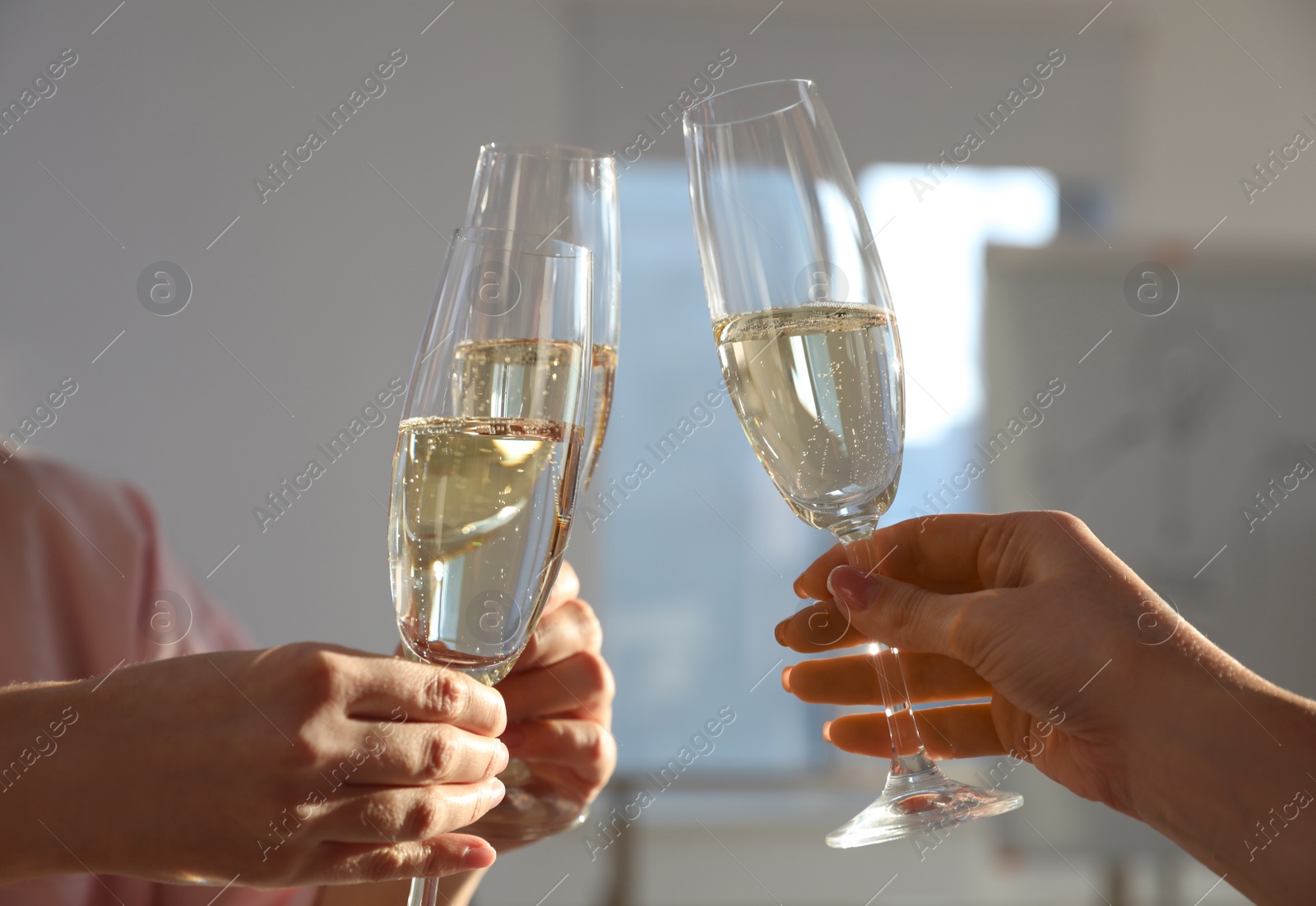 Photo of People clinking glasses of champagne in office, closeup. Holiday cheer and drink