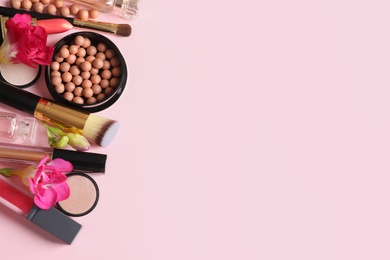 Photo of Different makeup products with flowers on color background. Space for text