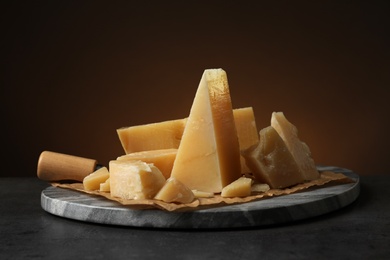 Photo of Marble board with delicious cheese on table