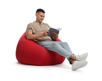 Photo of Handsome man reading book on red bean bag chair against white background