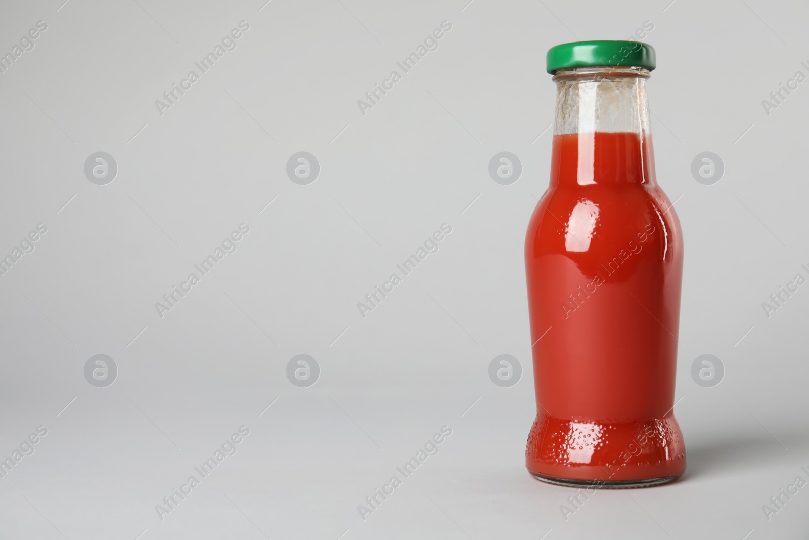 Photo of One bottle with tasty drink on color background. Space for text