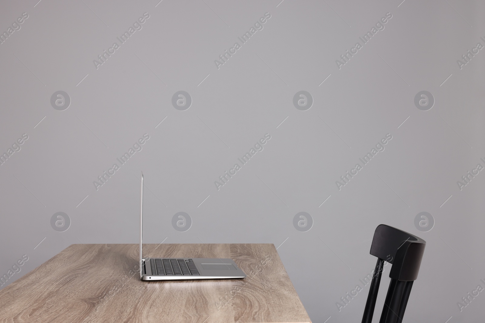 Photo of New modern laptop on empty wooden table indoors, space for text