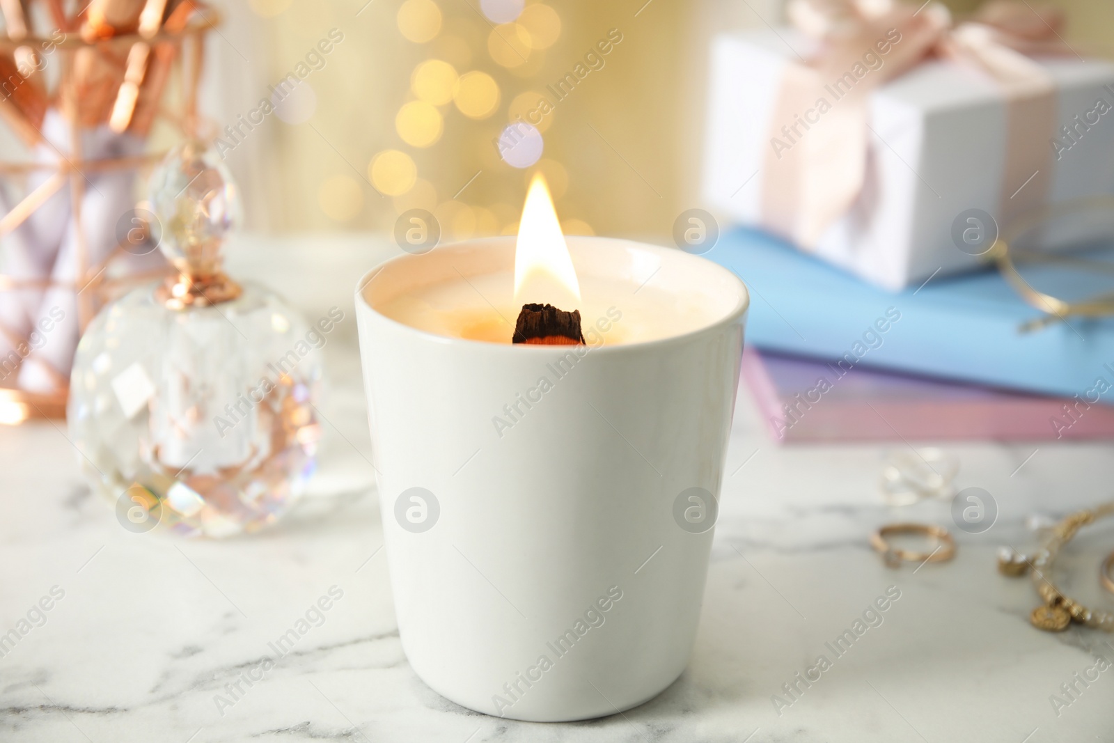 Photo of Burning candle with wooden wick on white table