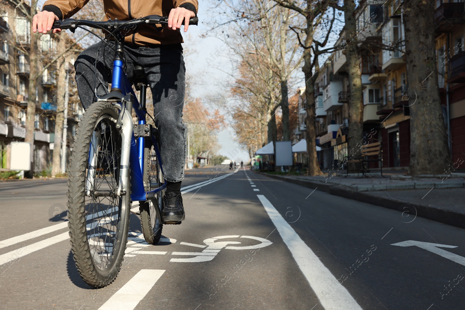 Photo of Man riding bicycle on lane in city, closeup