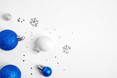 Photo of Colorful Christmas balls and sparkles on white background, top view