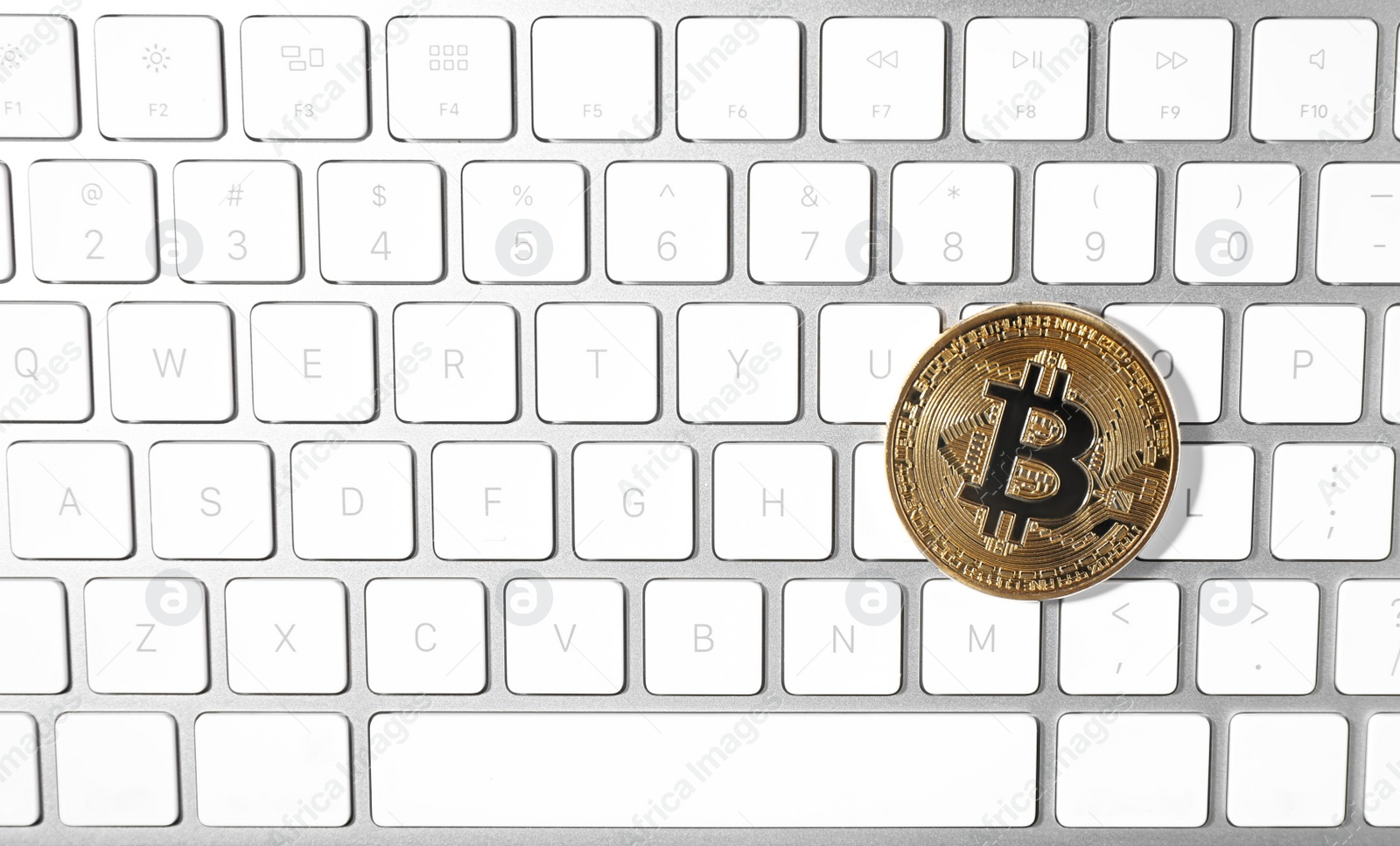 Photo of Golden bitcoin on computer keyboard, top view. Space for text