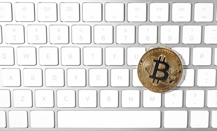 Photo of Golden bitcoin on computer keyboard, top view. Space for text