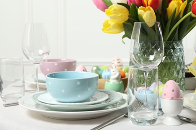 Easter celebration. Festive table setting with beautiful flowers and painted eggs