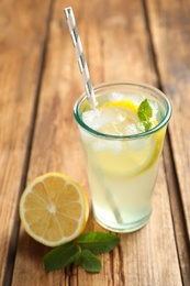 Photo of Natural lemonade with mint and fresh fruit on wooden table, closeup. Summer refreshing drink