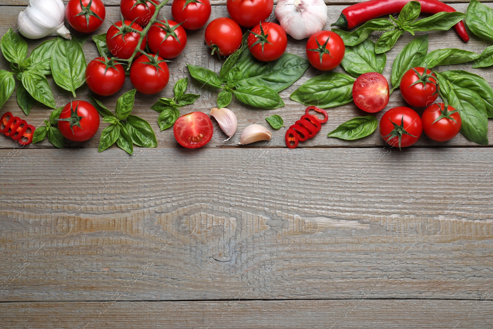 Photo of Flat lay composition with fresh basil leaves and vegetables on wooden table. Space for text