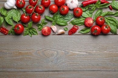 Flat lay composition with fresh basil leaves and vegetables on wooden table. Space for text