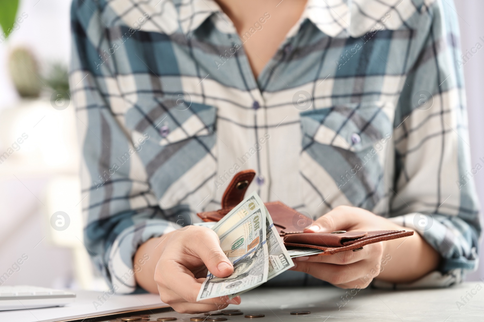 Photo of Woman with money at light grey table, closeup