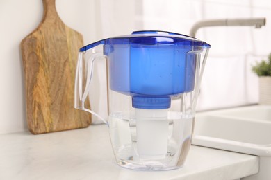 Photo of Water filter jug on white countertop in kitchen