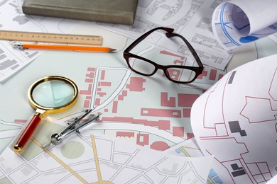 Photo of Office stationery and eyeglasses on cadastral map of territory with buildings
