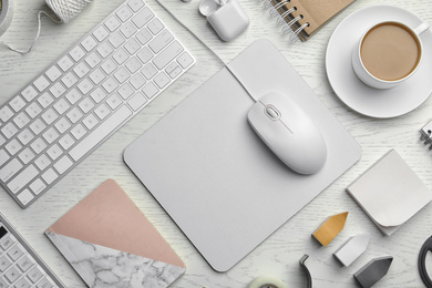 Photo of Flat lay composition with wired computer mouse, keyboard and stationery on white wooden table