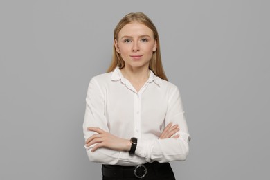 Photo of Portrait of beautiful young woman in white shirt on grey background