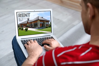 Image of Man searching for house on rental property website via laptop, closeup