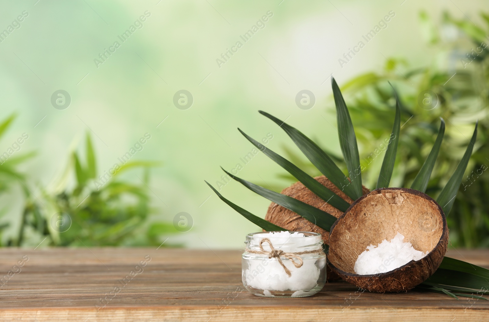 Photo of Composition with natural organic coconut oil on wooden table. Space for text