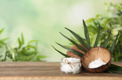 Composition with natural organic coconut oil on wooden table. Space for text