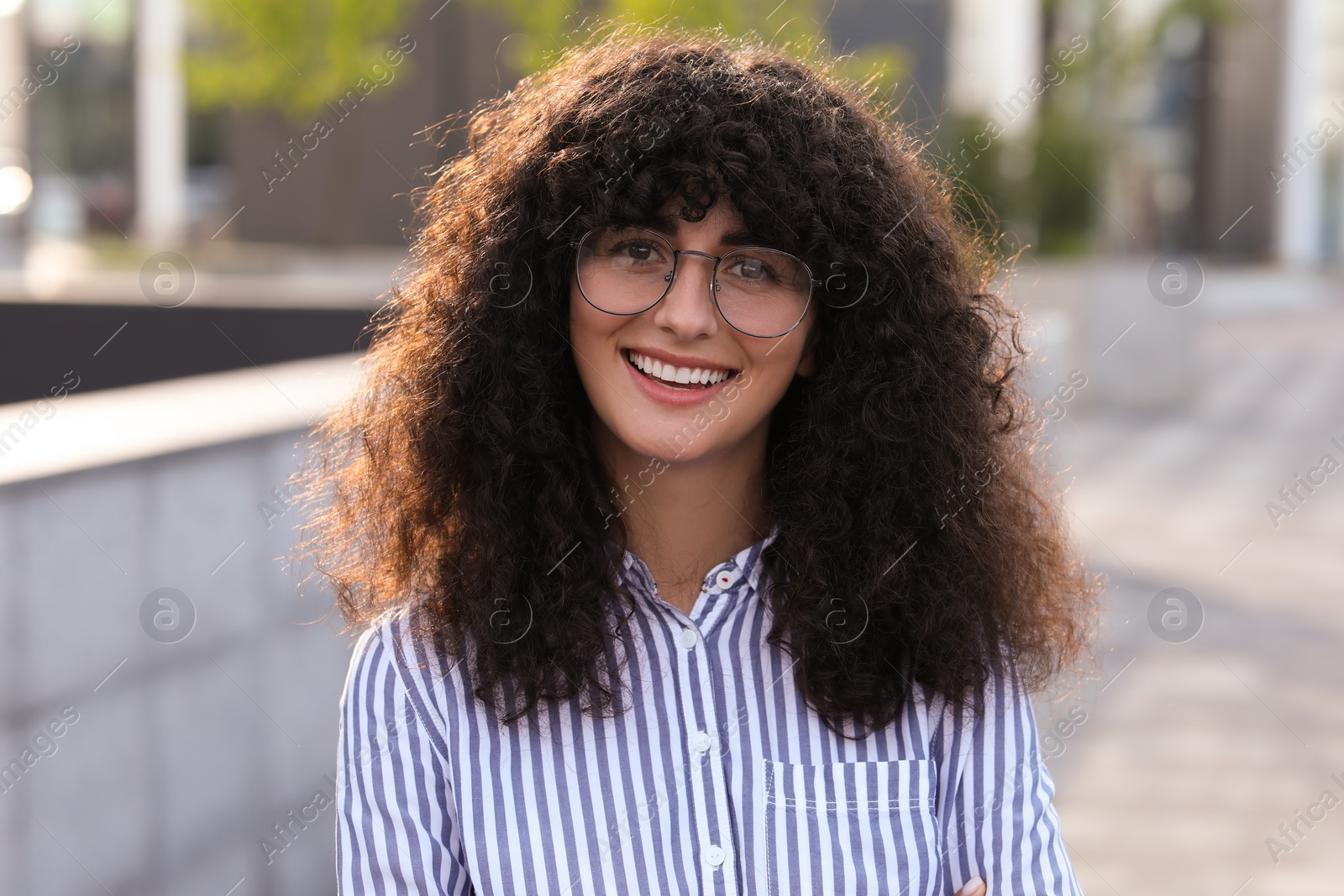 Photo of Portrait of beautiful woman in glasses outdoors. Attractive lady smiling and posing for camera