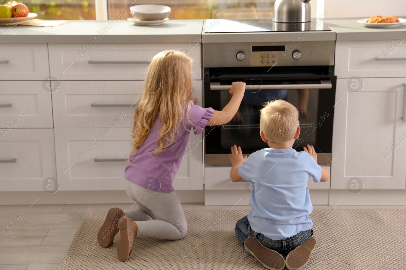 Photo of Little kids baking something in oven at home