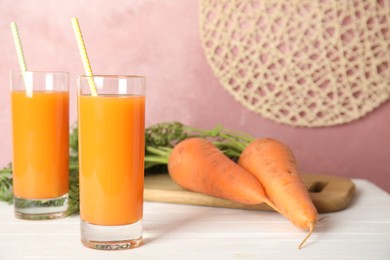 Freshly made carrot juice on white wooden table