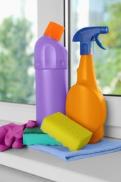 Photo of Cleaning supplies and tools on window sill indoors