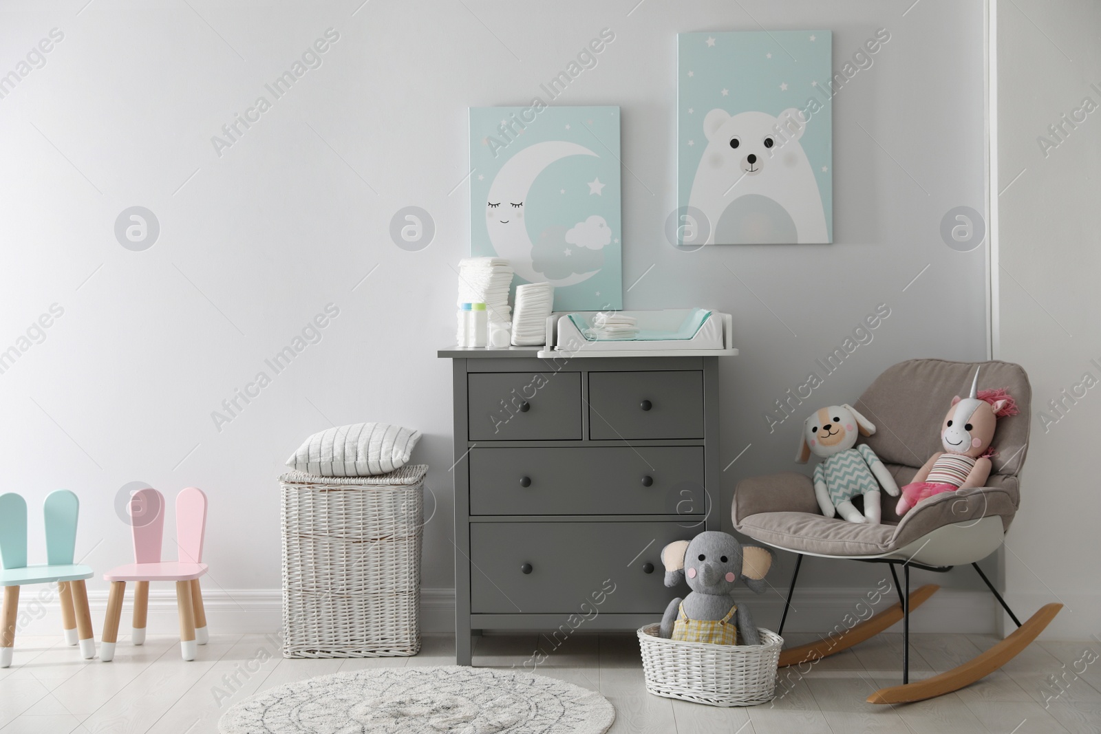 Photo of Chest of drawers with changing tray and pad in baby room. Interior design