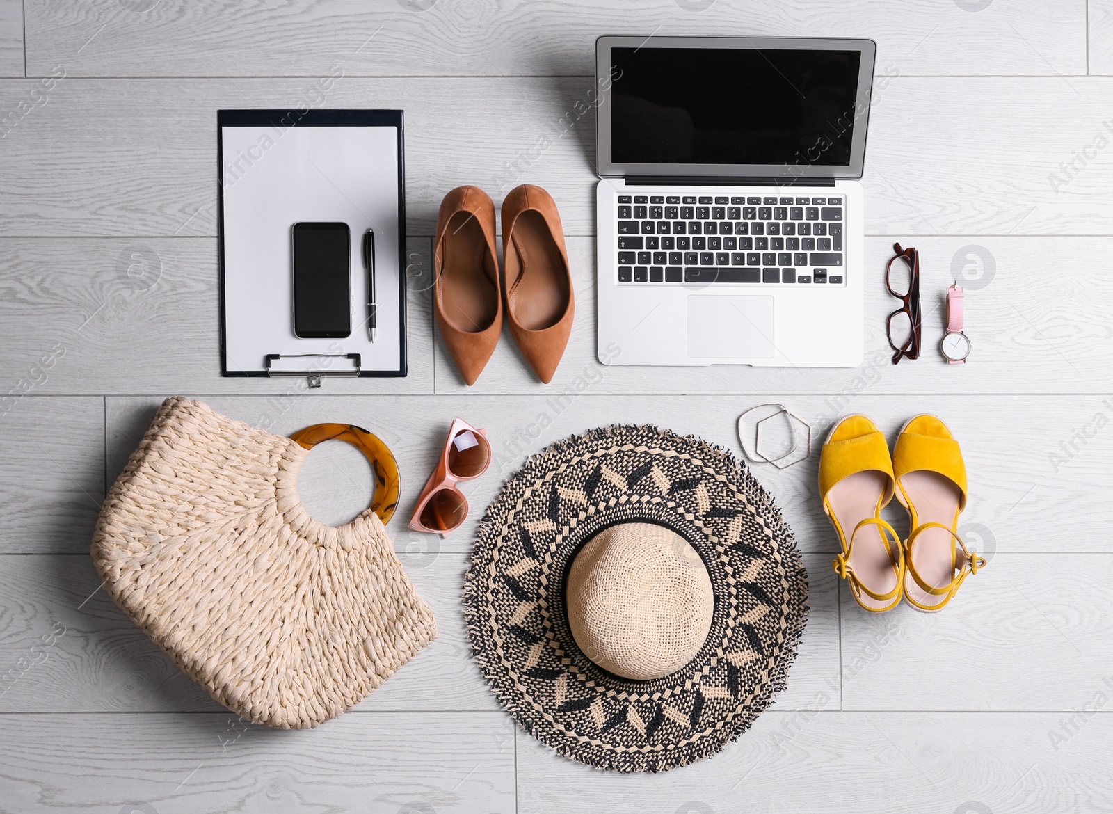 Photo of Flat lay composition with business supplies and beach accessories on white wooden floor. Concept of balance between work and life