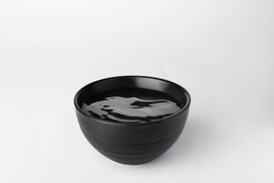 Photo of Black bowl full of water on white background
