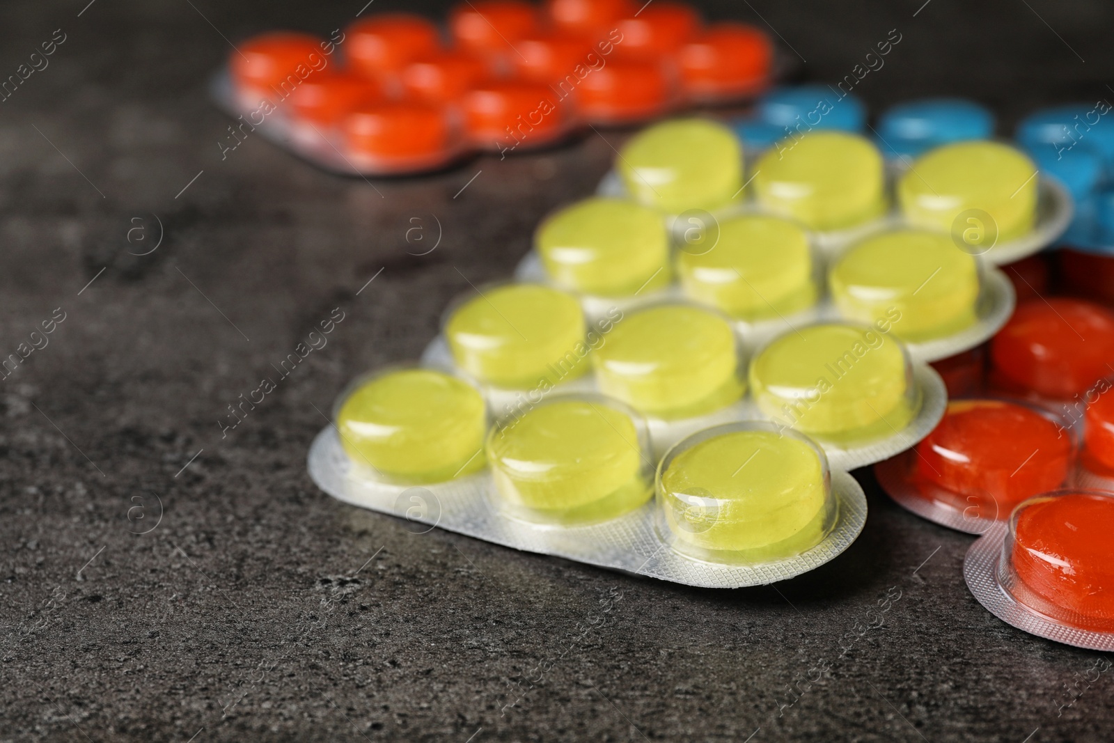 Photo of Blisters with color cough drops on table