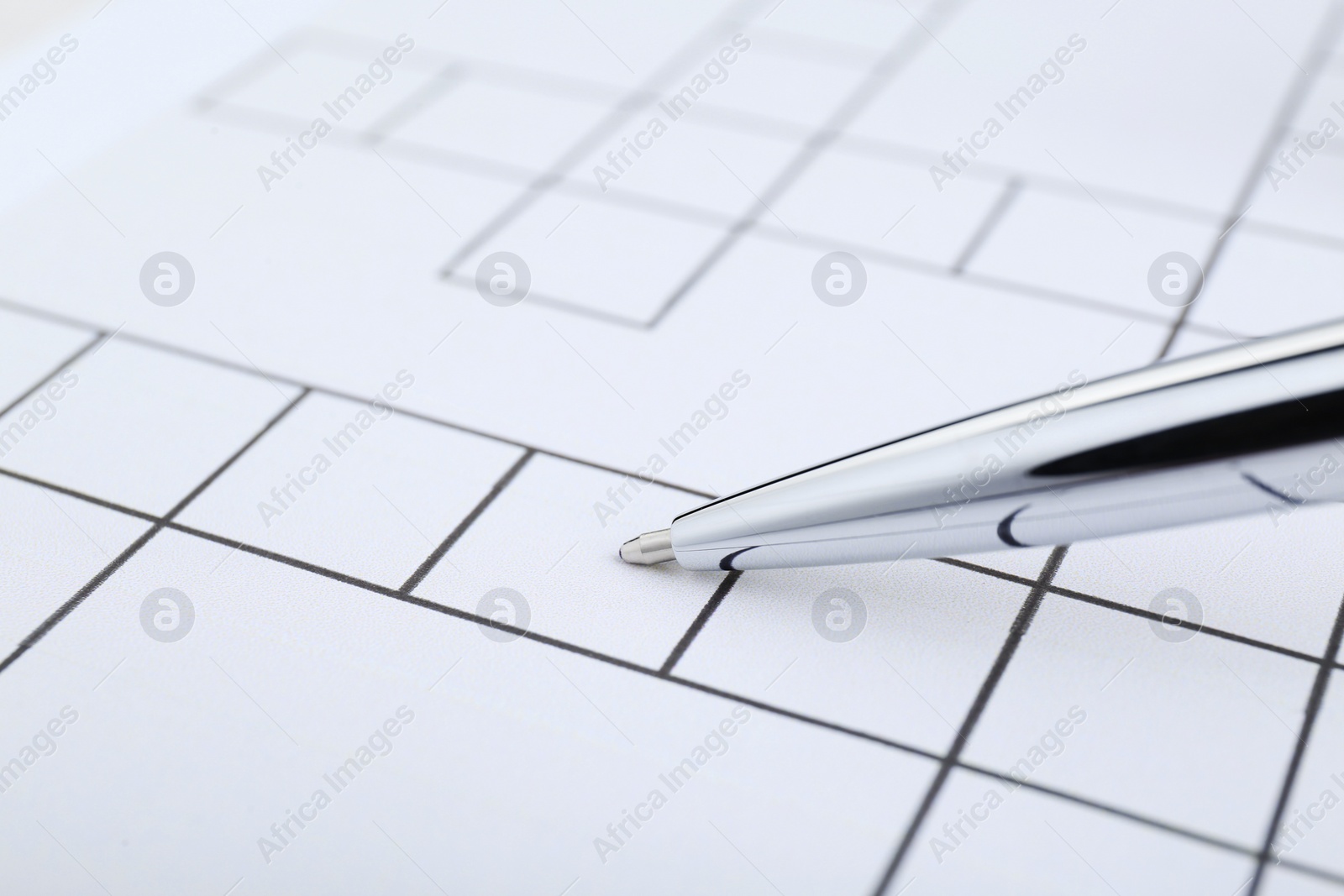 Photo of Pen on blank crossword, closeup. Space for text